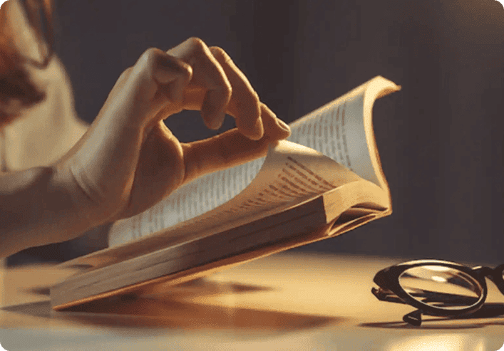 A writer working at a desk beside a window